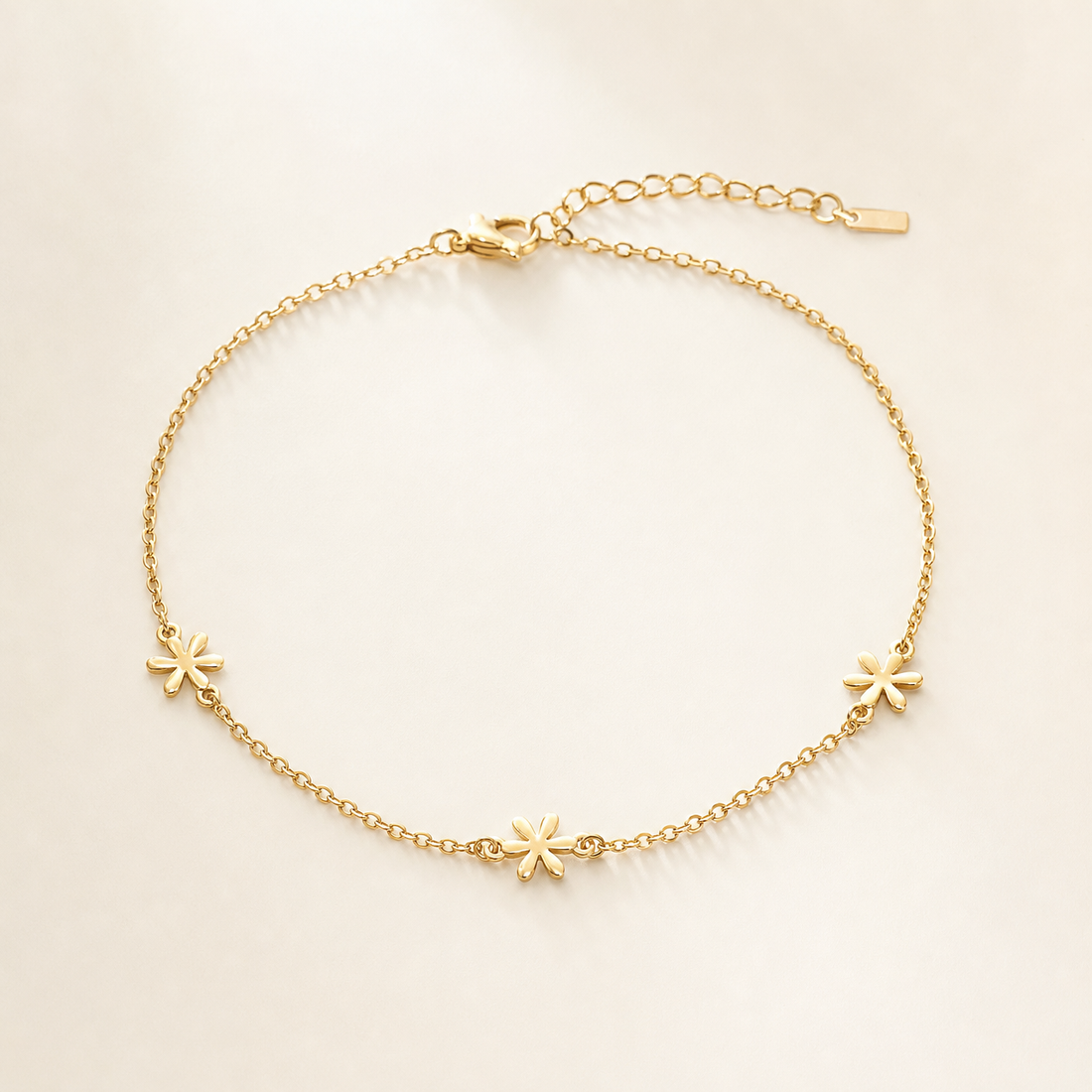 One anklet in yellow-gold-toned metal with a bright polished finish. It is a single-strand fine cable chain of small uniform oval links, unbroken except for three solid-metal star-shaped station charms spaced along it. The full chain run is approximately 30 times the width of the largest star charm, ankle length.