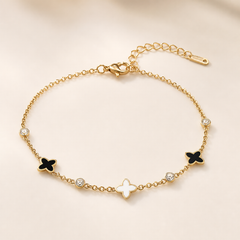 One anklet. Yellow-gold-tone metal with a polished finish. Single-strand fine cable chain of small oval links, with one lobster-claw clasp and a short extender chain ending in a small bar tag; a working closure is visible. The main chain run is approximately fifteen times the width of the largest motif, and the extender is roughly one-quarter of the main chain. Decoration occupies one decorated run rather than the full length, with plainer chain toward the clasp and extender.