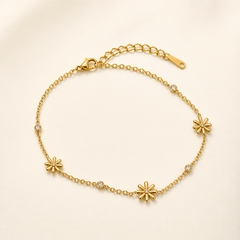 One anklet. Yellow-gold-tone metal with a polished finish. A single-strand fine cable chain of small oval links carries distributed stations along its full length and is fitted with one lobster clasp plus one adjustable extender chain of larger cable links ending in one flat elongated pierced terminal tag; the closure is visibly workable.