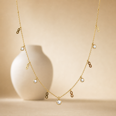 One necklace, yellow-gold in colour with a polished finish, built as a single fine cable chain of small gauge links with tiny bead accents at intervals. The chain run measures roughly 40 times the width of the largest component; no extender chain is visible, so no extender fraction can be stated, and no working clasp is visible in view.