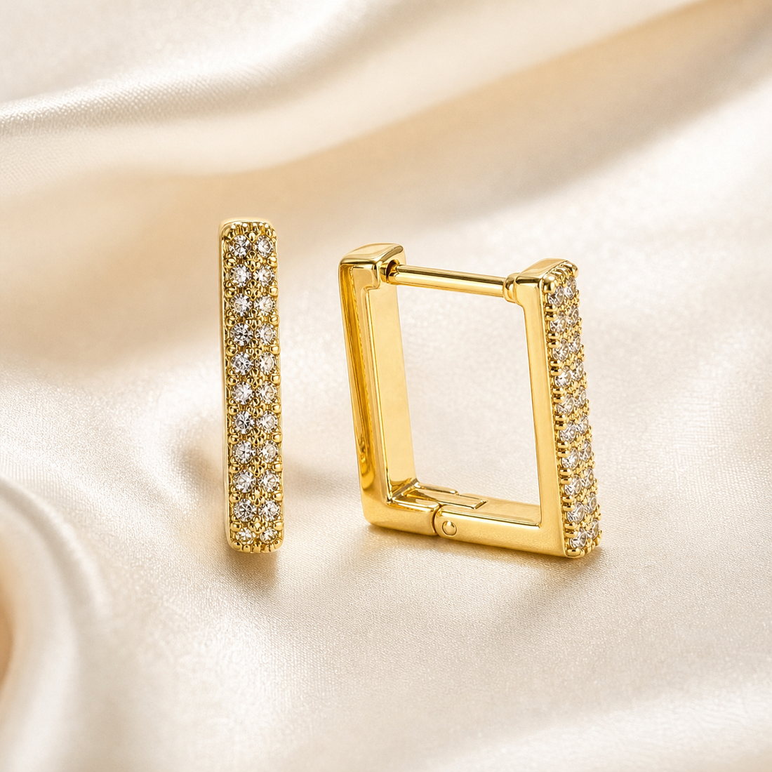 A matched pair of two small square-shaped huggie hoop earrings in yellow-gold-tone metal with a polished finish. Each earring is a rigid rectangular hoop with rounded corners and a hinged closure, the post and hinge visible at the top edge of one earring; the band is of medium gauge with flat side walls and a smooth inner face.