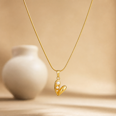 Single necklace: one fine yellow-gold snake chain of polished finish, a single unbroken strand of very fine, tightly woven links with no branches, carrying one dominant pendant. The visible chain run measures roughly 20 to 25 times the pendant's width, consistent with neck length; the clasp end is not shown, so no closure, extender or terminal tag is visible, and extender length cannot be assessed. From the bail outward the ledger is: a tapered polished gold bail, then a jump ring, then the pendant itself.