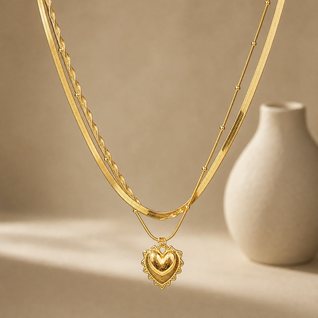 One necklace in yellow-gold-toned polished metal, built as three joined parallel strands sharing common end connections. The strands are: a wide flat herringbone chain; a fine snake chain punctuated by small round ball stations spaced irregularly along its run; and a second fine snake chain, set at a slightly longer drop, that carries the pendant. The longest chain run measures roughly 30 times the pendant's width; no extender chain is visible.