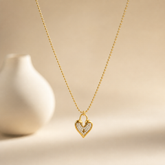One necklace in yellow-gold-toned metal with a polished finish, constructed as a single continuous strand of small uniform round bead (ball-chain) links of fine gauge, with no branches or joins along its run. The chain run is approximately 25 to 30 times the width of the pendant, the largest component, indicating neck length; no extender chain is visible, so no extender fraction can be stated, and no working clasp, jump ring closure, or terminal tag is resolved in the visible portions.