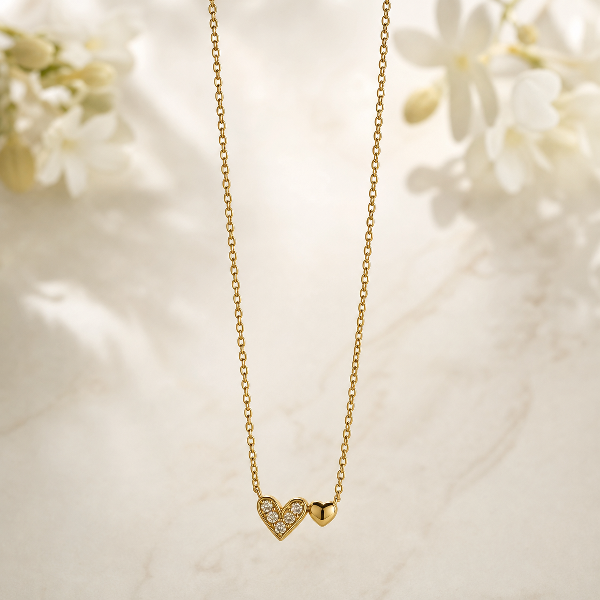 One necklace in yellow-gold-tone metal with a polished finish. It is a single-strand fine cable chain of small oval links, continuous with no branches; the visible chain run is roughly 40 times the width of the largest component. No clasp, extender or terminal tag is visible; the closure area is partly obscured beyond the frame of view, so a working closure cannot be confirmed.