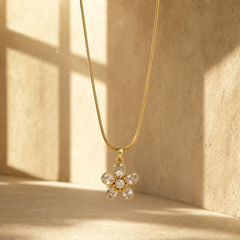One necklace in gold-toned metal with a polished finish, built as a single fine-gauge snake chain of tight, smooth round profile with no branching, carrying one dominant pendant on a fixed tapered bail. The visible chain run is long, roughly 40 to 45 times the pendant's width, indicating neck length; the chain continues out of frame, so the clasp end is not visible and no working closure, extender or terminal tag can be confirmed.