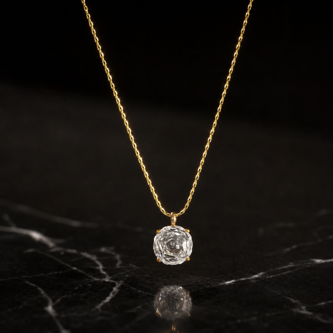 One single-strand pendant necklace in yellow-gold-toned metal with a polished, slightly textured finish. The chain is a single fine, low-gauge twisted/rope-style link chain forming one continuous run; its visible length is roughly 40 to 45 times the width of the pendant, the largest component. No working clasp is visible in the image, and no extender chain or terminal tag is visible; the closure area is partly obscured, so the extender fraction cannot be confirmed.