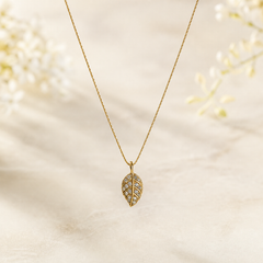 One necklace in warm yellow-gold-toned metal with a polished finish, comprising a single fine strand and one dominant pendant. The chain is a very fine-gauge twisted or textured rope-style chain of a single continuous strand; no working clasp, extender or terminal tag is visible, and the chain ends run partly beyond the observable area, so closure hardware is unresolved.