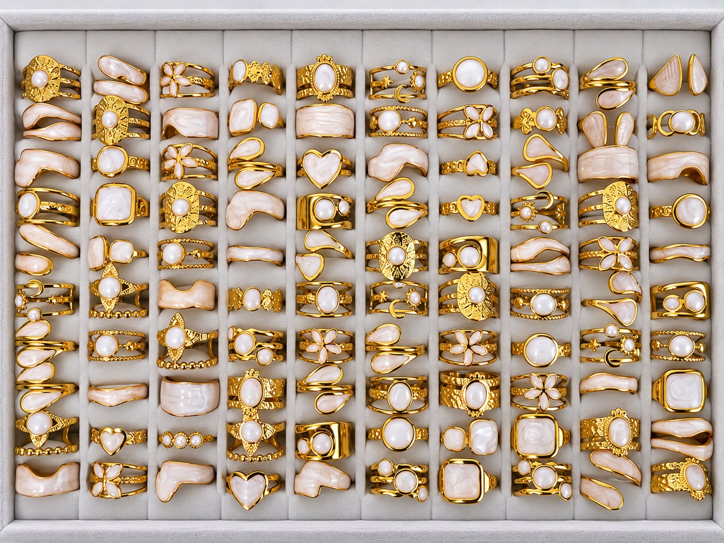 Gold-tone 304 stainless steel rings with pearl-white stones and cream enamel, a mixed set of 50 pieces laid out in a tray