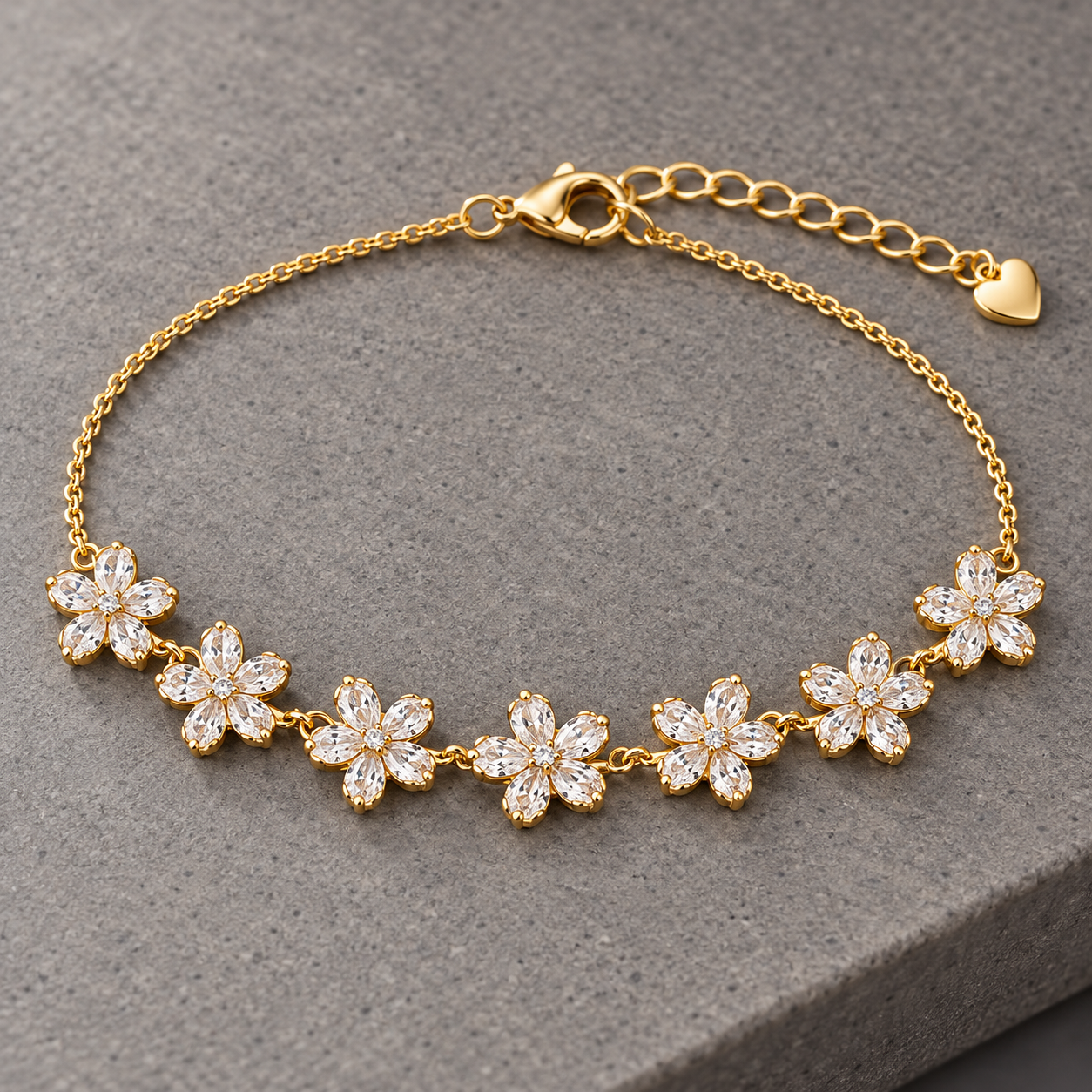 Gold-tone 316L stainless steel chain bracelet with seven crystal-set flower motifs and a heart charm, laid flat