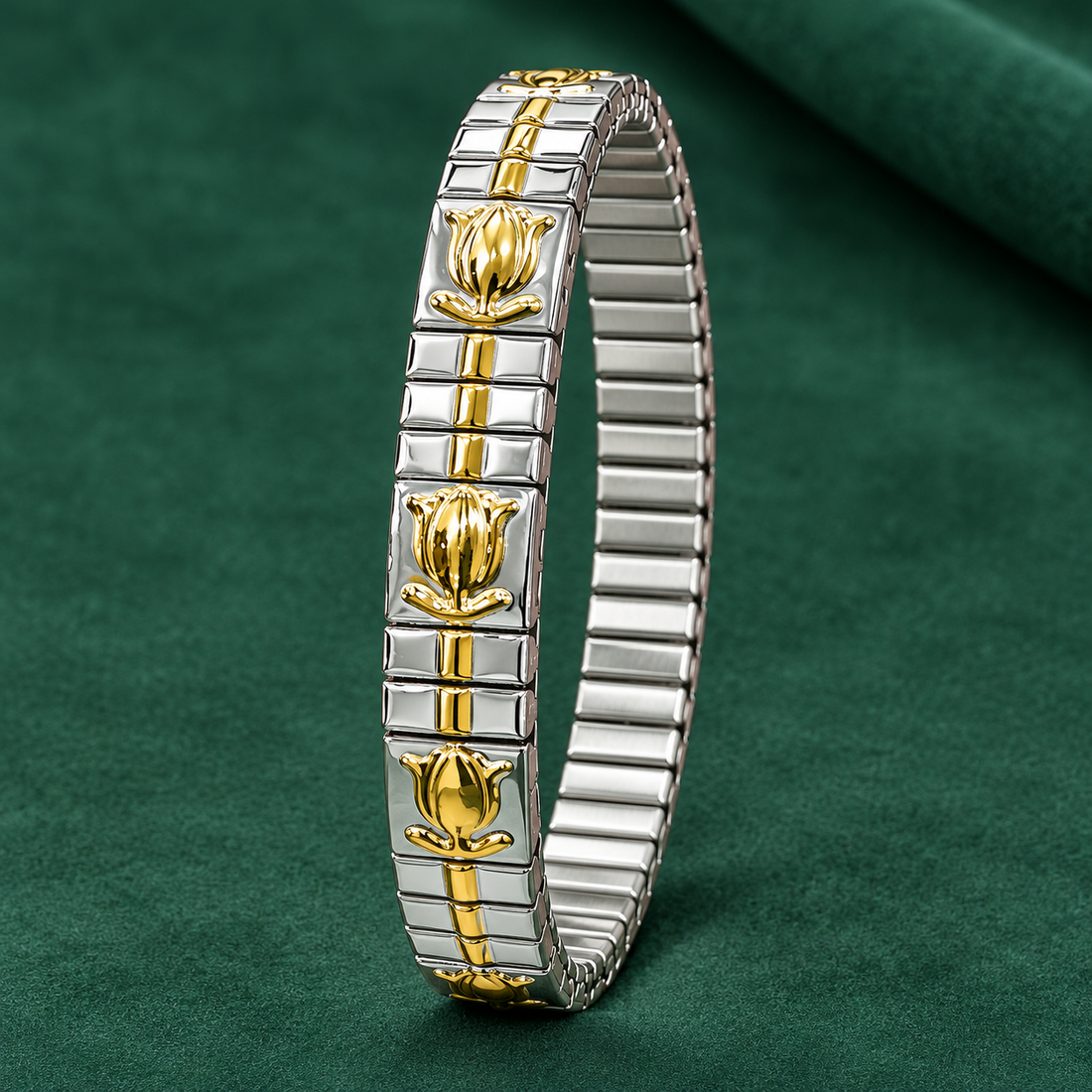 Two-tone stretch bracelet of 304 stainless steel with gold-tone tulip motifs on silver-tone link plates, shown lying flat on a green cloth