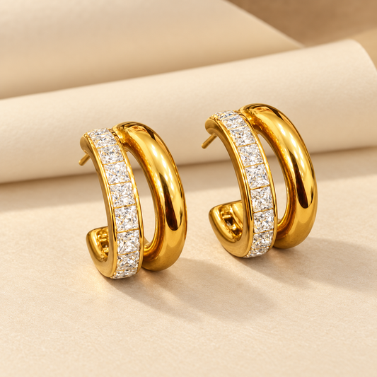 Gold-tone 316L stainless steel double-hoop earrings with a row of square clear crystals on the outer hoop and a smooth inner hoop, shown as a pair