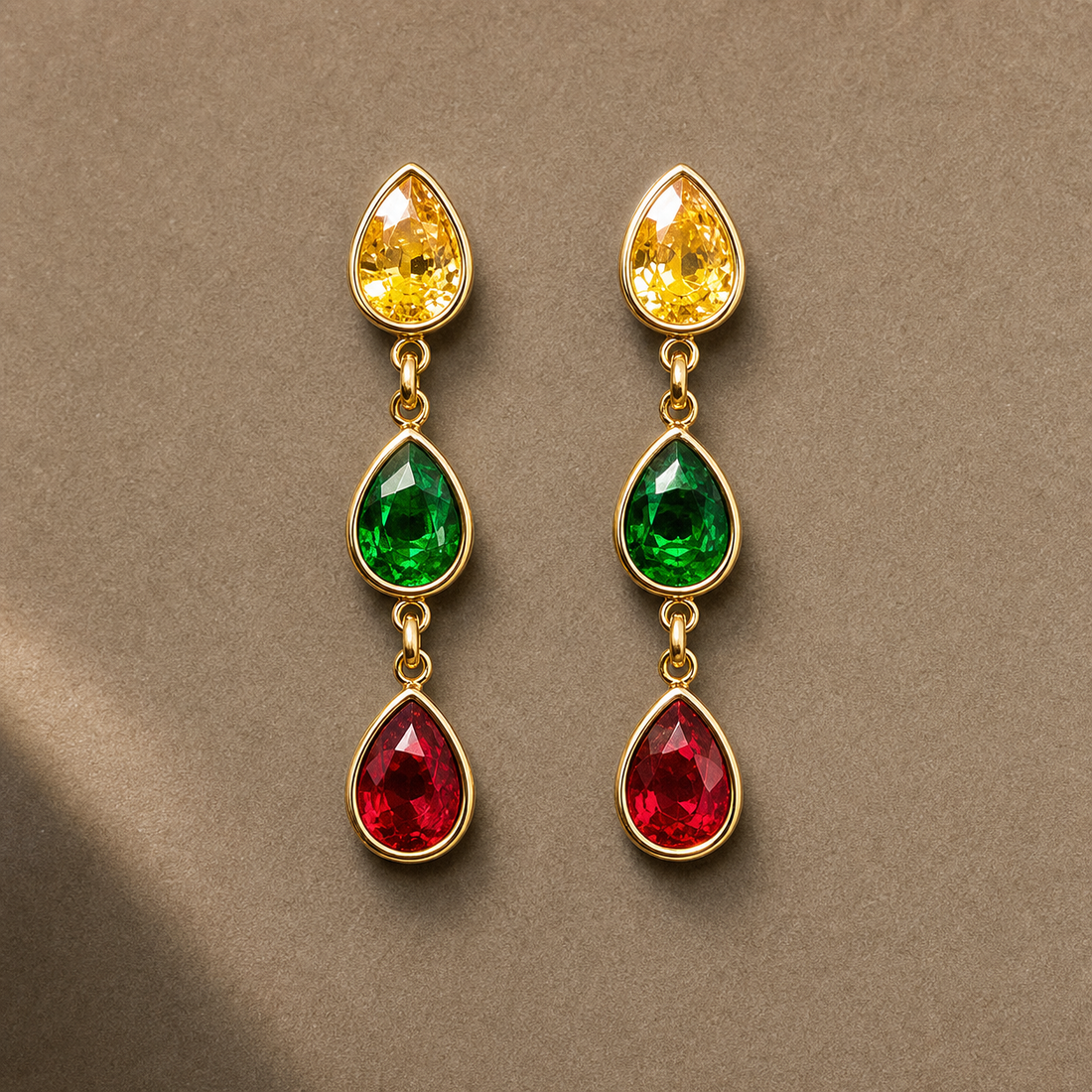 Gold-tone 304 stainless steel drop earrings with three pear-cut stones in yellow, green and red, set in bezels, shown as a pair