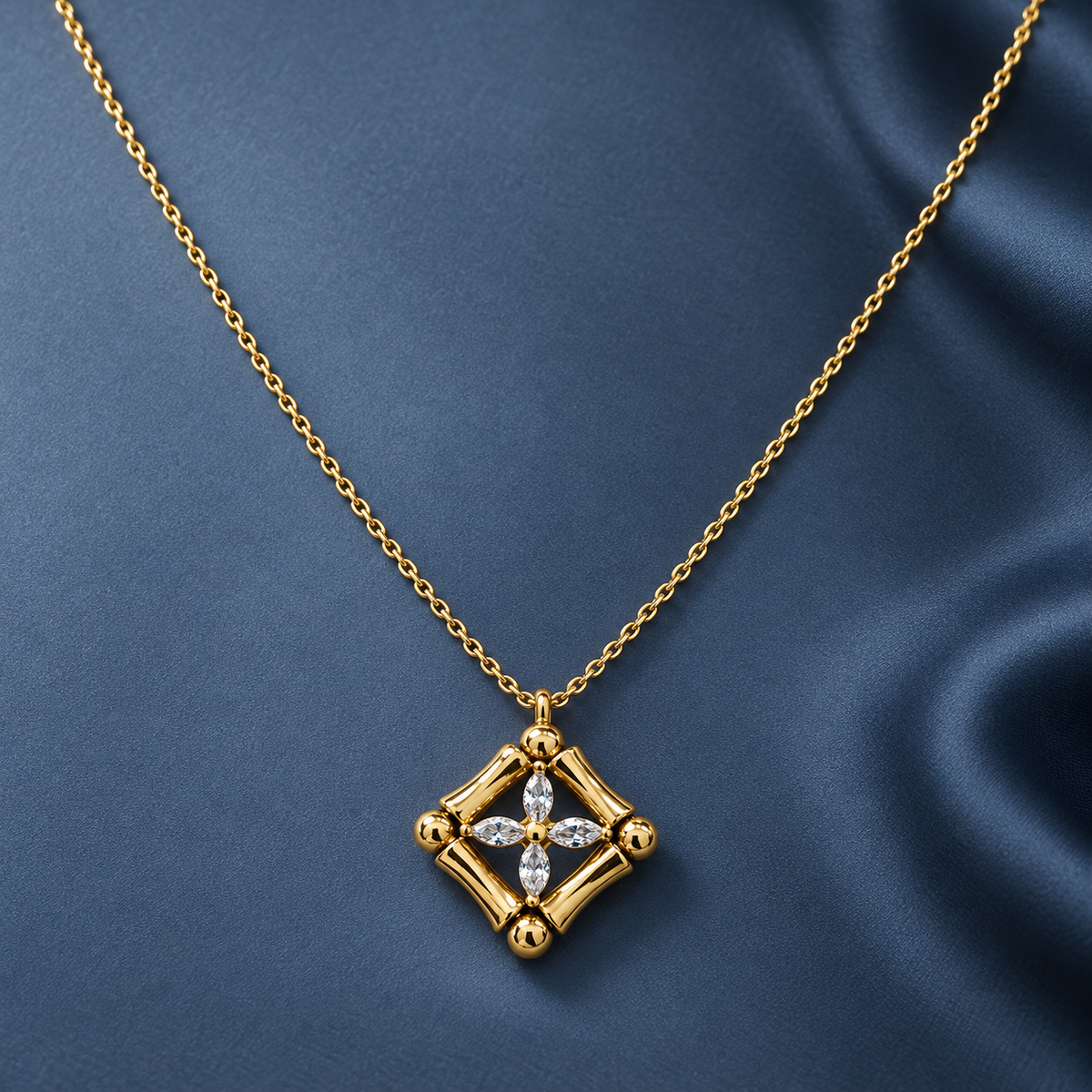 Gold-tone 316L stainless steel pendant necklace with a diamond-shaped frame of bamboo-style links and four marquise stones, on a fine chain