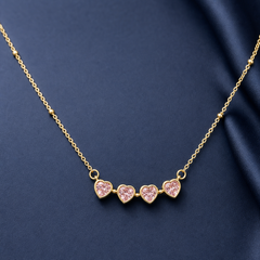 Gold-tone 304 stainless steel necklace with four pink heart-shaped stones in bezel settings on a fine chain with small bead accents