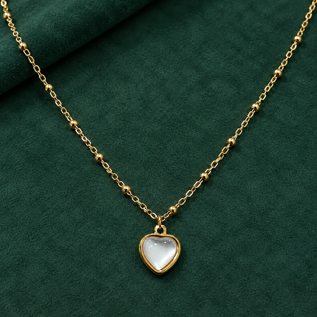 Gold-tone 316L stainless steel necklace with a bead-accented chain and a white heart pendant set in a gold-tone bezel