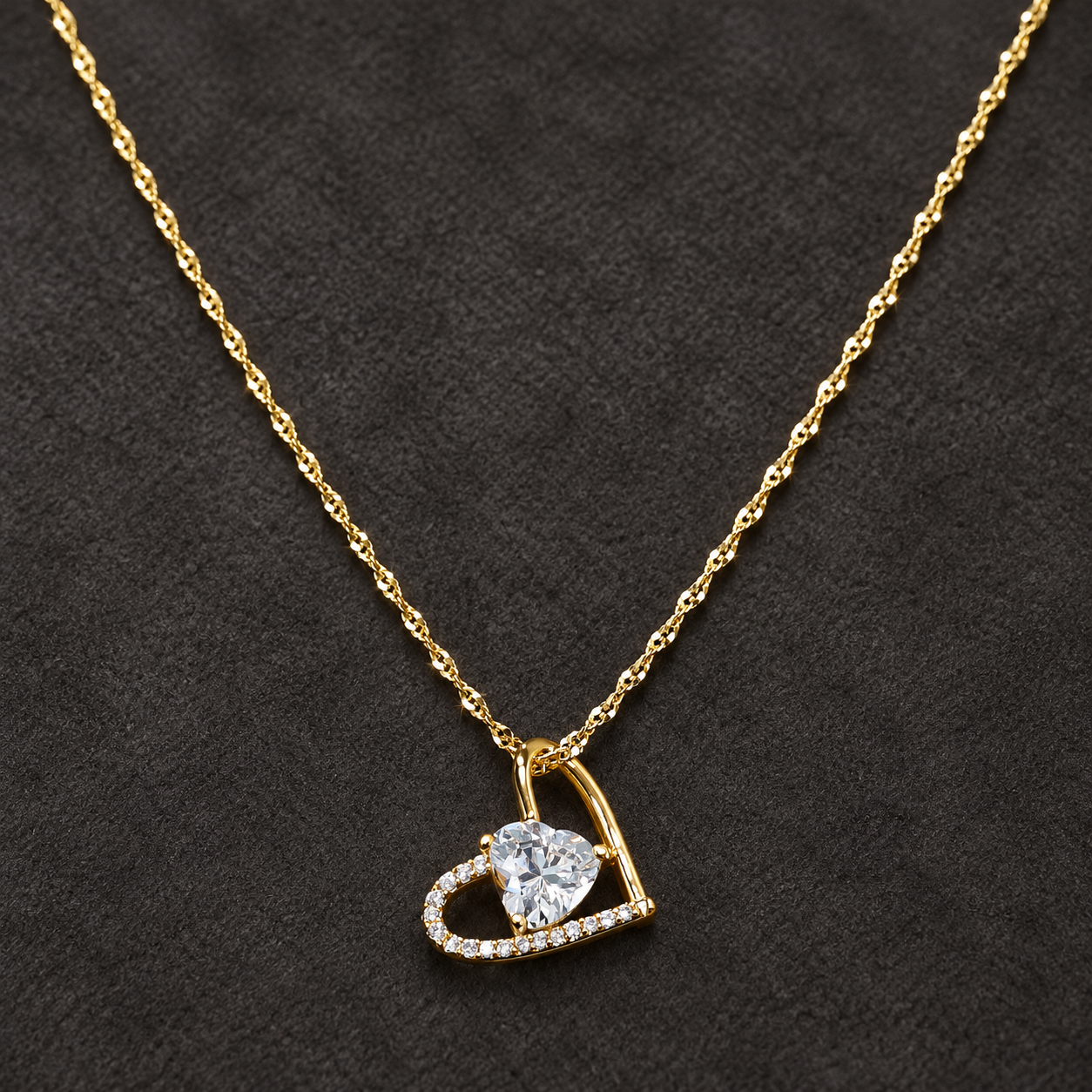 Gold-tone 316L stainless steel heart pendant necklace with a clear crystal heart centre and pavé outline on a twisted chain