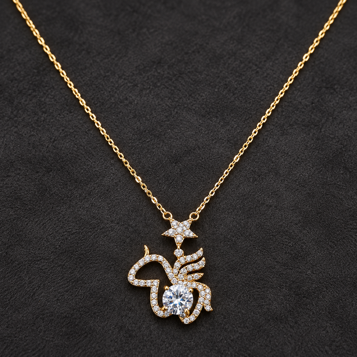 Gold-tone 316L stainless steel pendant necklace with a fine cable chain and a pavé crystal bird-shaped pendant topped by a star, worn on a dark background