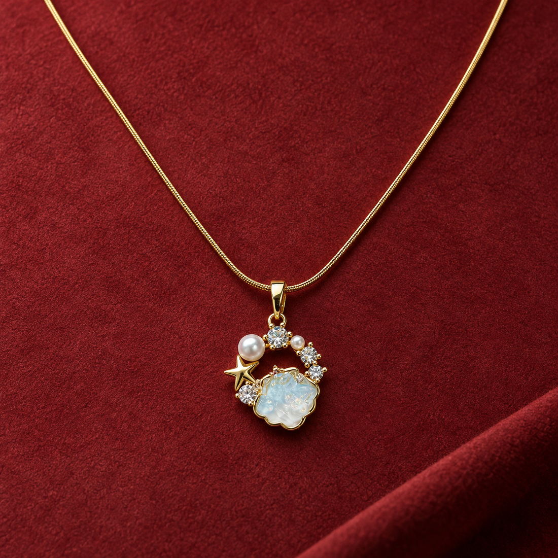 Gold-tone 316L stainless steel pendant necklace with a pale blue cloud-shaped centre stone, pearl, star and crystal accents on a snake chain