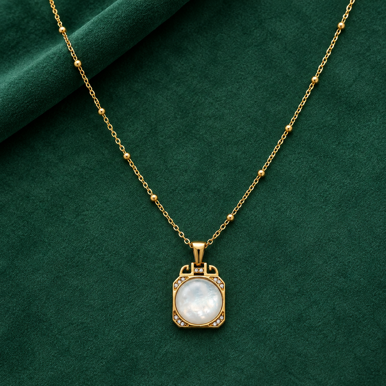 Gold-tone 316L stainless steel pendant necklace with a mother-of-pearl disc and crystal-set frame on a bead chain