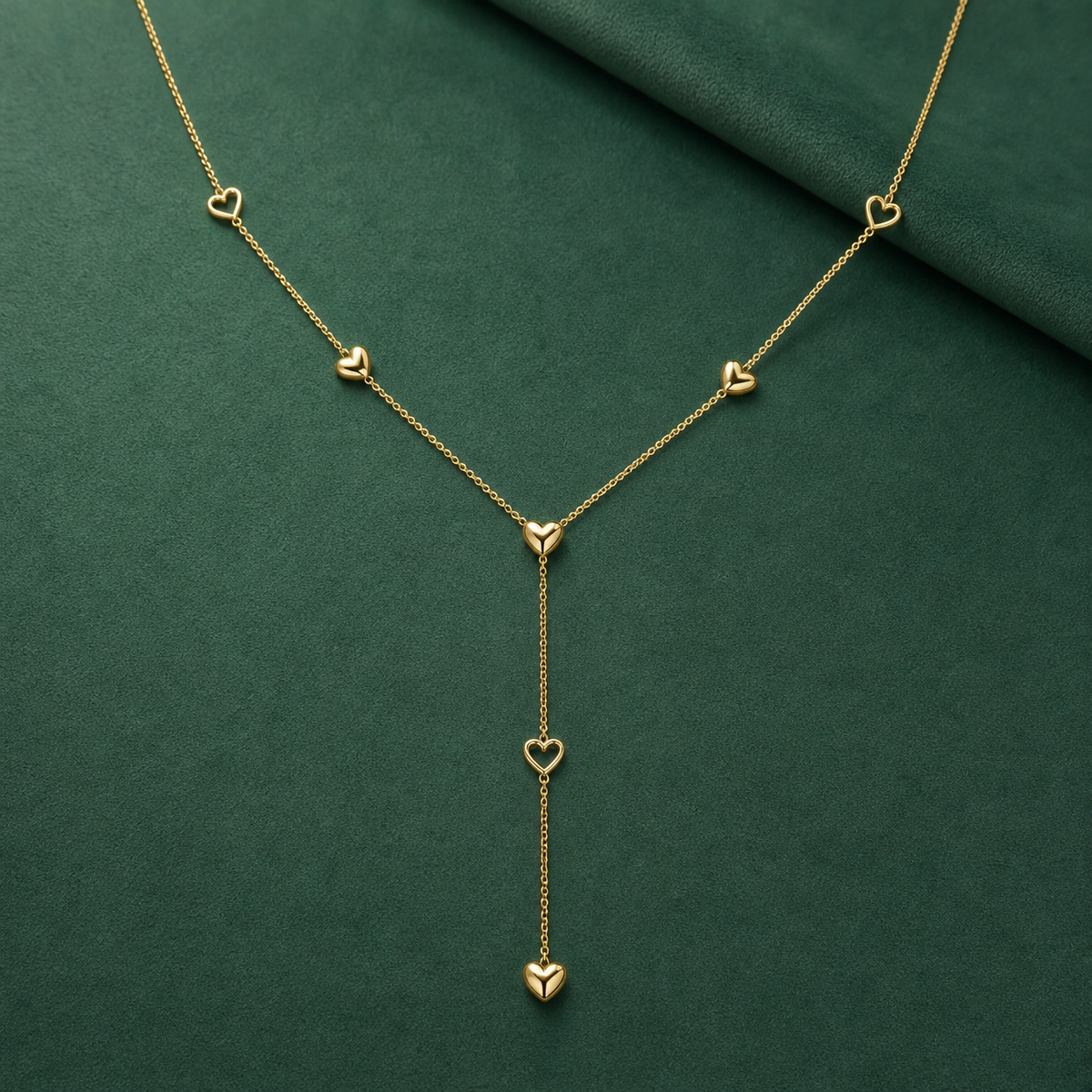 Gold-tone 316L stainless steel lariat necklace with a fine chain and small heart motifs, one pendant heart hanging on a drop chain