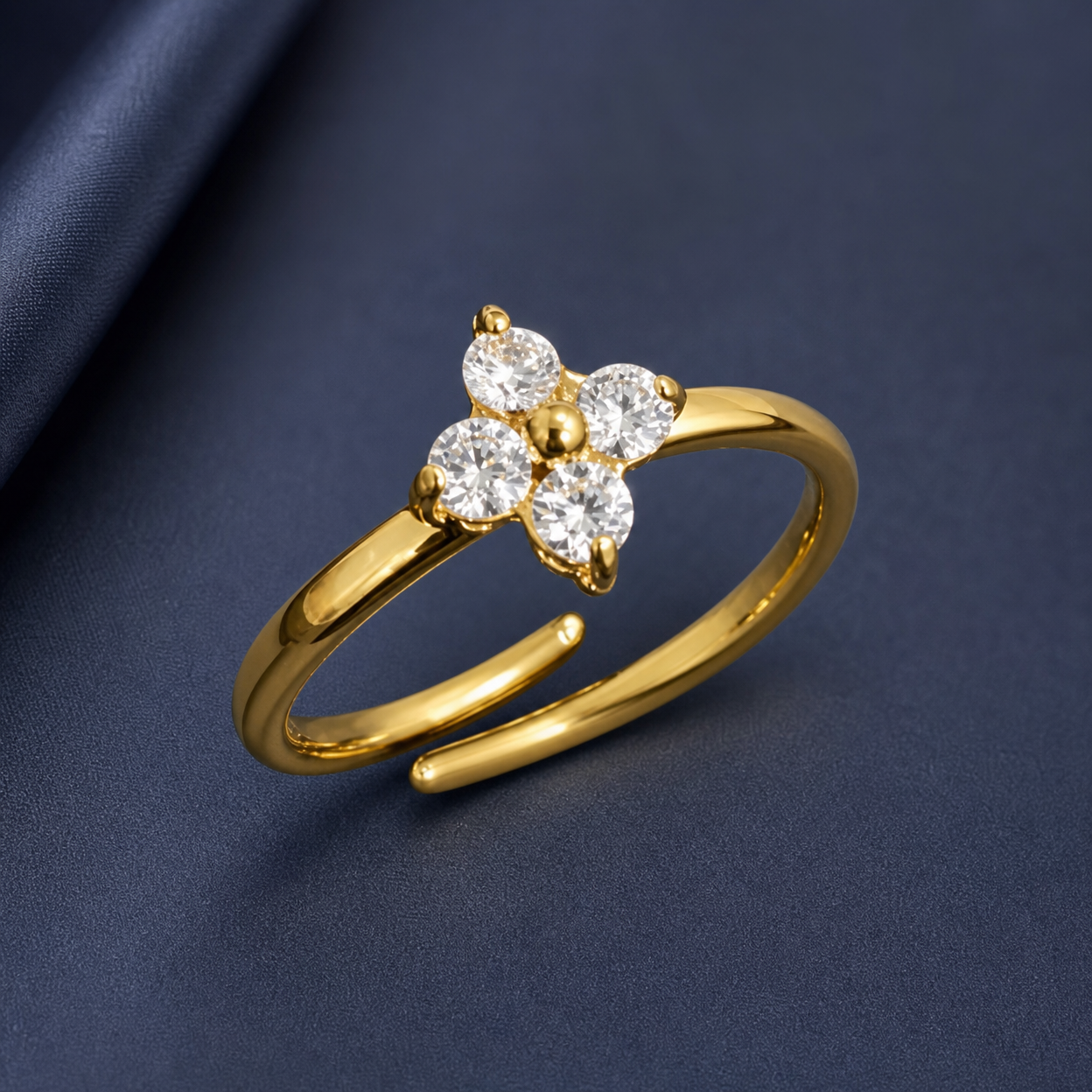 Gold-tone 316L stainless steel adjustable ring with four clear crystals set in a flower cluster on a thin band, shown from an angle