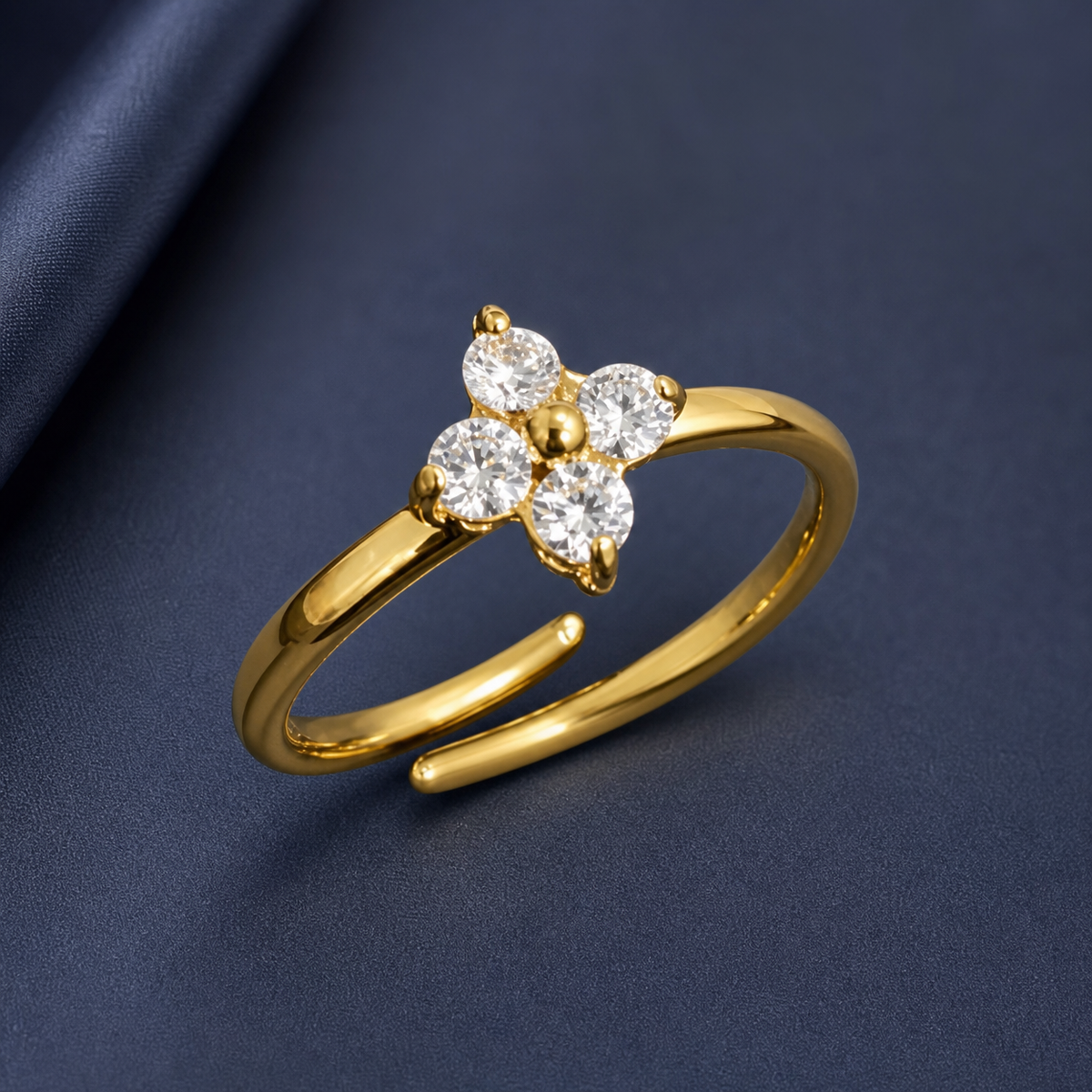 Gold-tone 316L stainless steel adjustable ring with four clear crystals set in a flower cluster on a thin band, shown from an angle