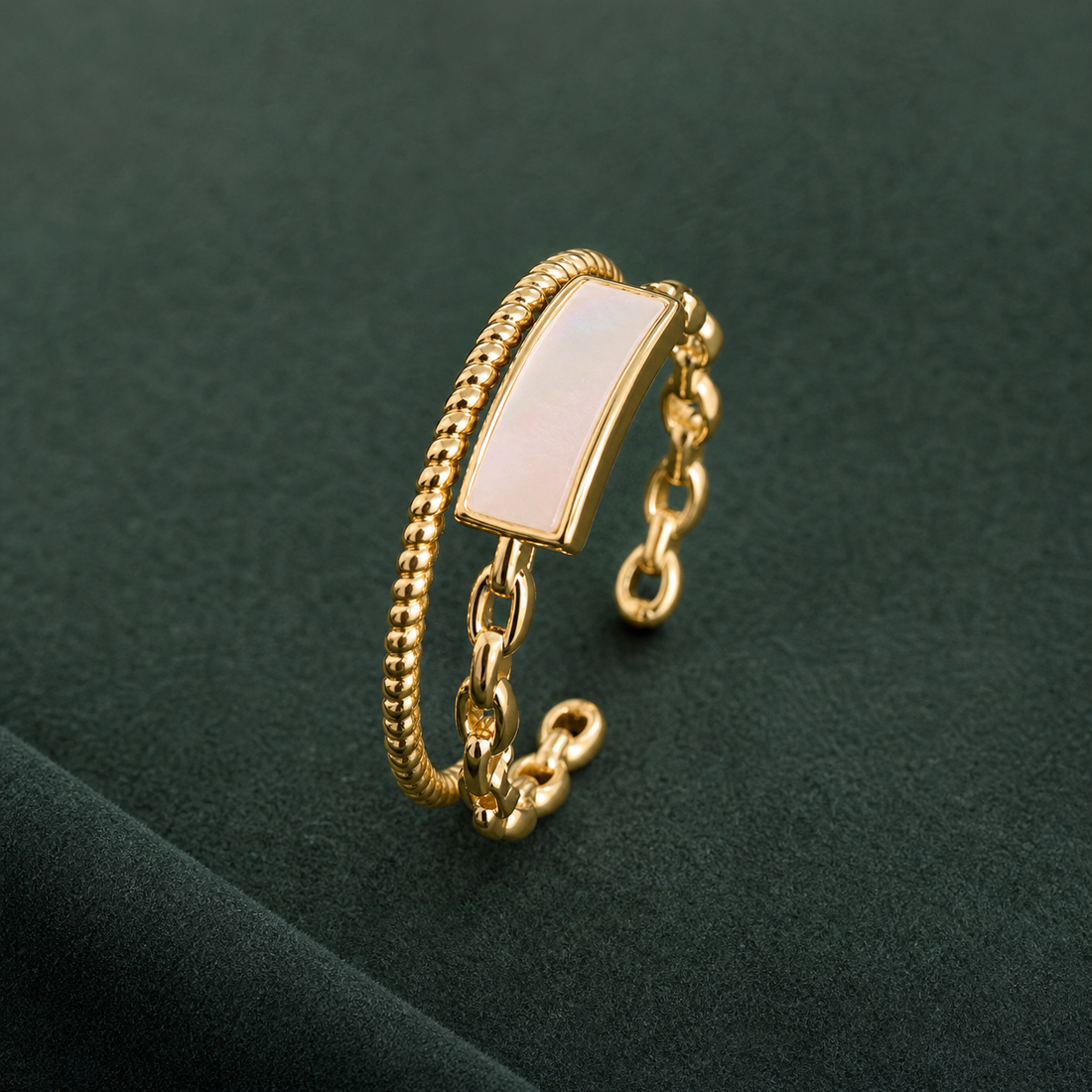Gold-tone 316L stainless steel open ring with a beaded band, a link chain and a rectangular mother-of-pearl panel, shown on a dark surface