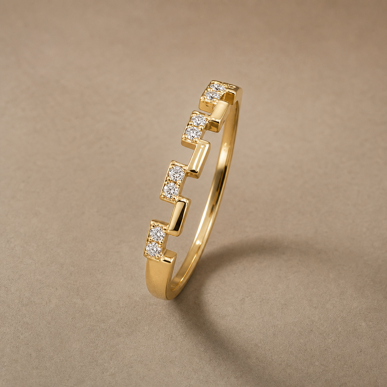 Gold-tone 304 stainless steel stacking ring with a stepped block design set with small clear stones, shown at an angle